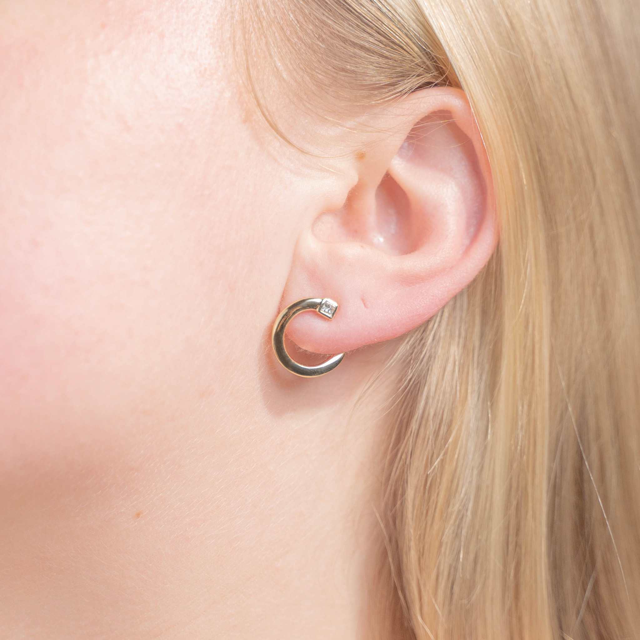 rudiment earrings on woman's ear